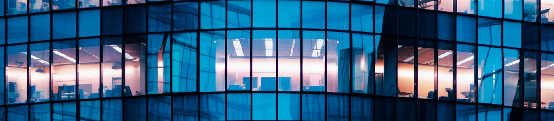 Vista nocturna del edificio de oficinas con ventanas iluminadas