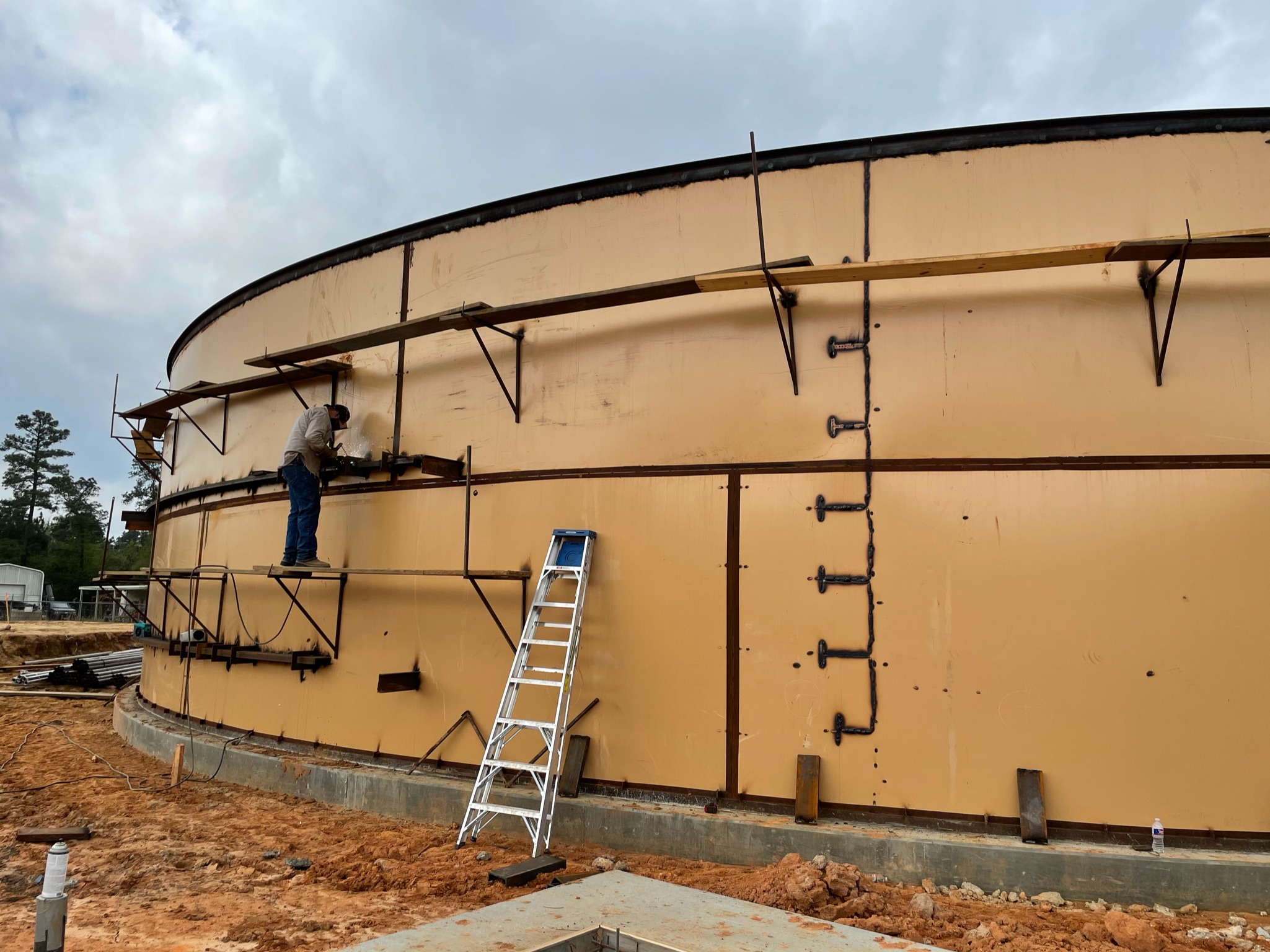 Technician installing steel concentric wastewater treatment tank during plant expansion in Magnolia, Texas