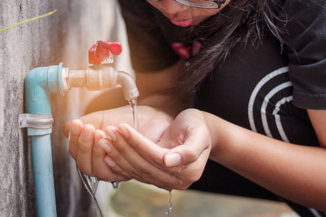 Public Health Risks of Water Service Disruptions Girl Retrieving Water From Outdoor Faucet