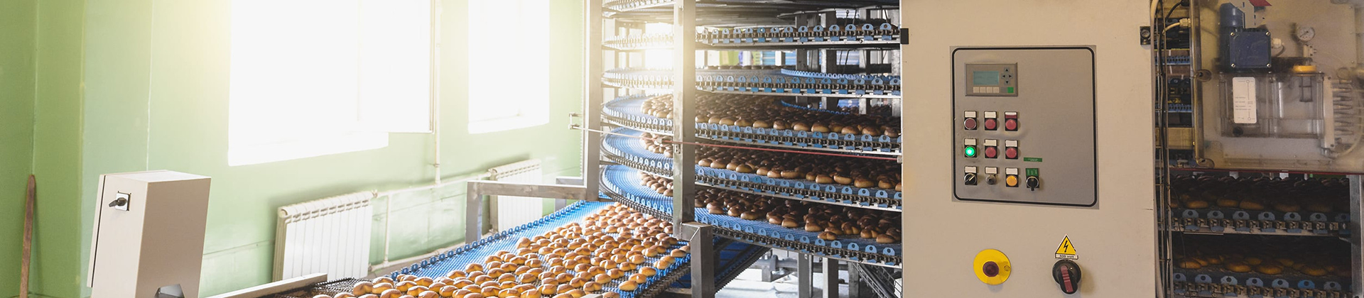 Food manufacturing facility using water reuse strategies for long-term growth Pastries moving along a conveyor line in a food manufacturing facility